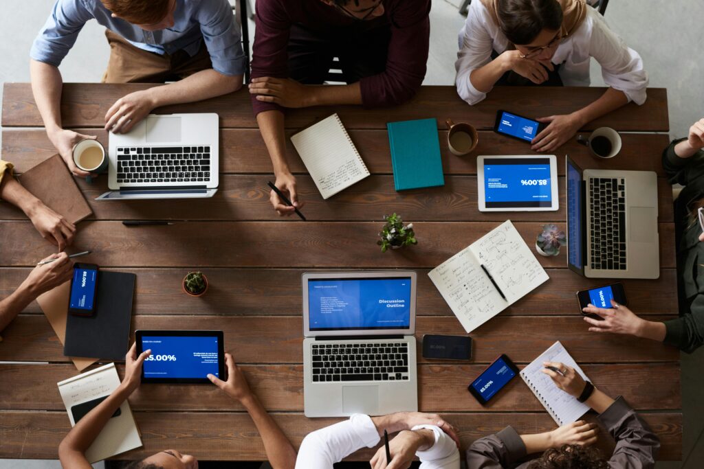 A direct marketing strategy team working around a wooden table.